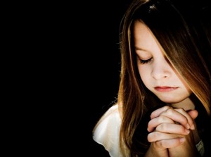 child-praying-black-background